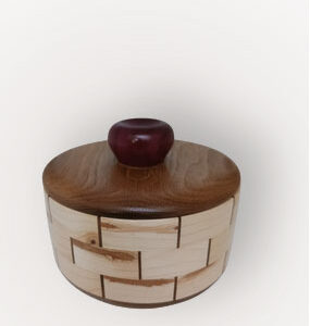 Cuenco de madera patchwork con patrón angular flotando sobre fondo blanco con sombra suave