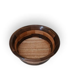 Patchwork wooden bowl with contrasting light and dark wood segments, floating over a white background with a subtle shadow